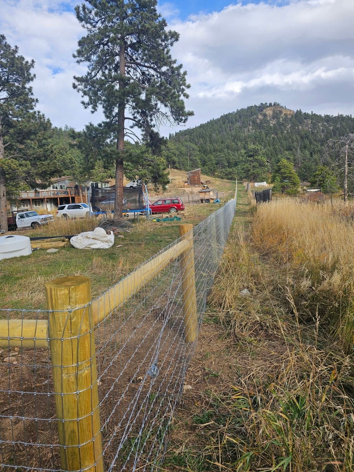 Wood post-and-rail fence with wire mesh
